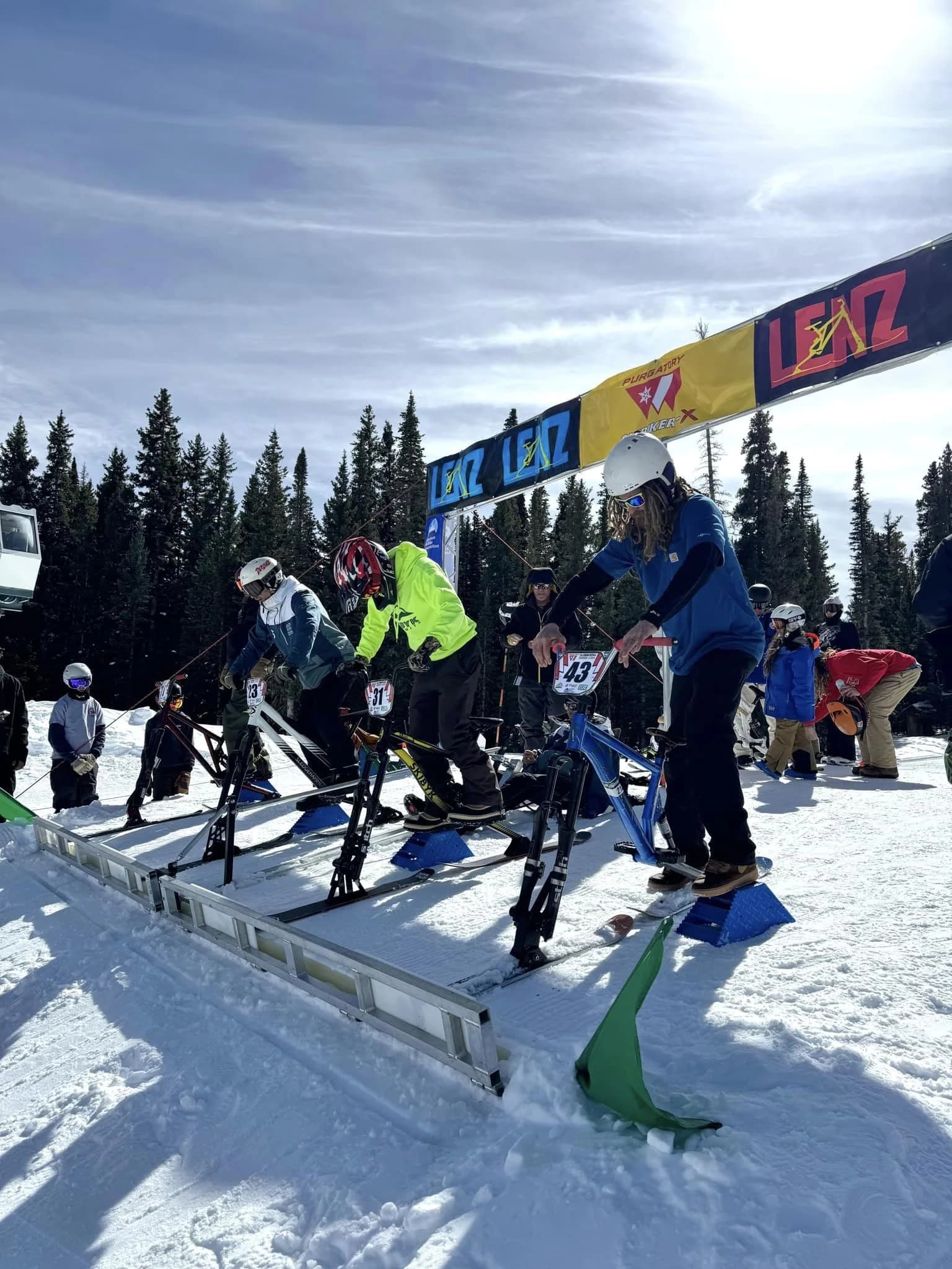 Rider wearing ASA colors leading a ski-bike pack down the course.